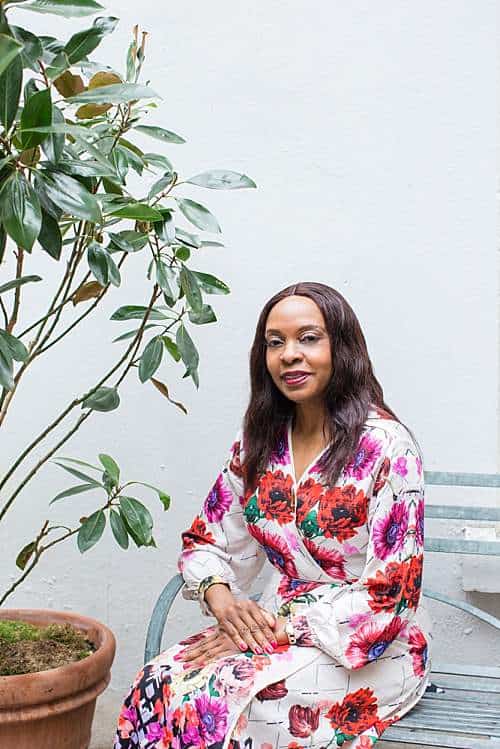 african-nigerian-woman-brand-photo-sit-on-chabby-chic-rustin-green-bench-by-olive-tree