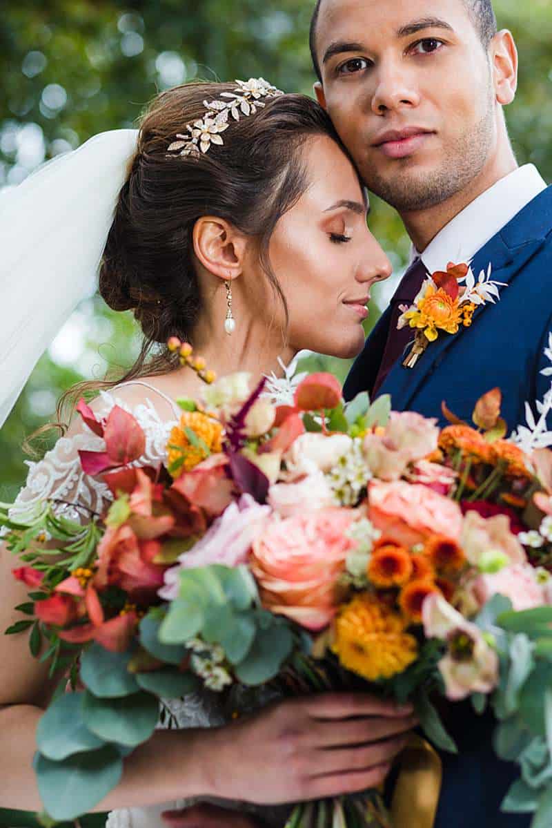 bride-leaning-into-groom-close-up-portrait-with-luxurious-autumn-wedding-bouquet