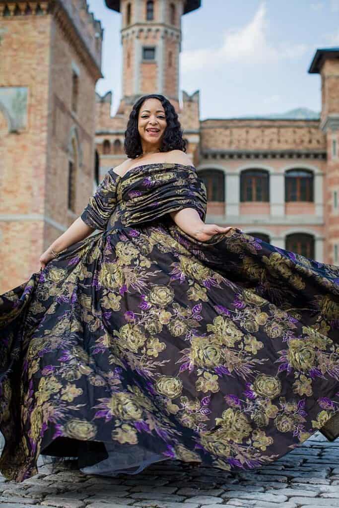 african-woman-in-couture-dress-dancing-in-front-of-castle-italy-tuscany