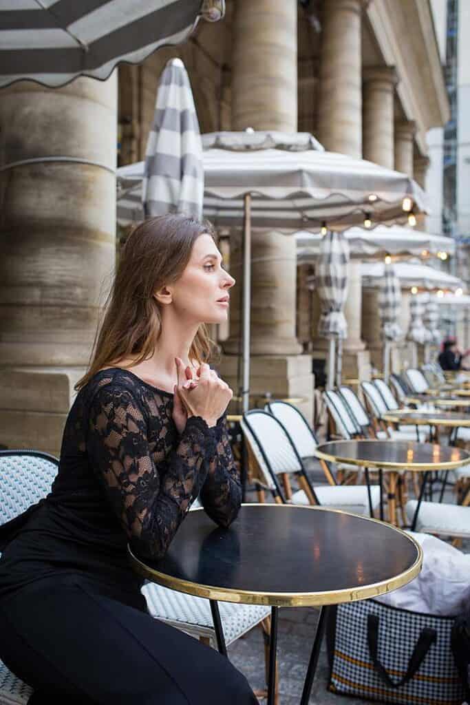 girl-sitting-at-paris-alfresco-cafe-in-elegant-black-dress-dreaming