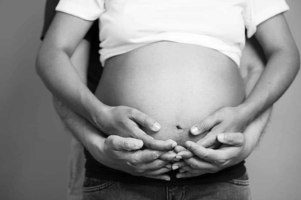 maternity-photography-man-holding-woman-pregnancy-belly