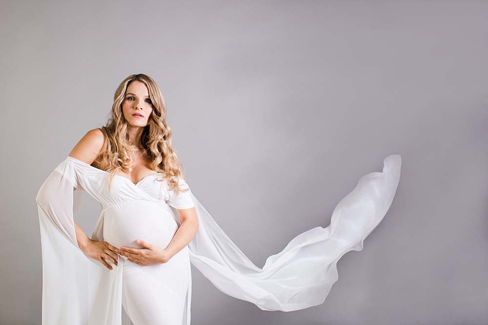 maternity-photography-woman-in-white-maternity-gown-fabric-flowing-by-london-maternity-photographer