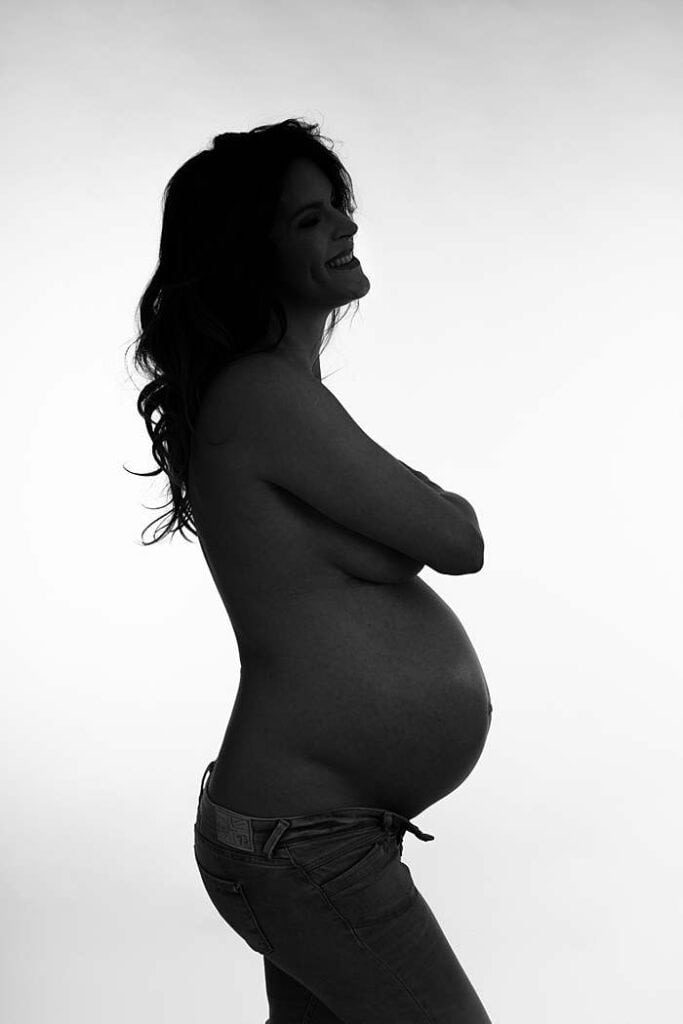 pregnancy-photo-in-silhouette-woman-in-open-jeans-maternity-boudoir-shoot