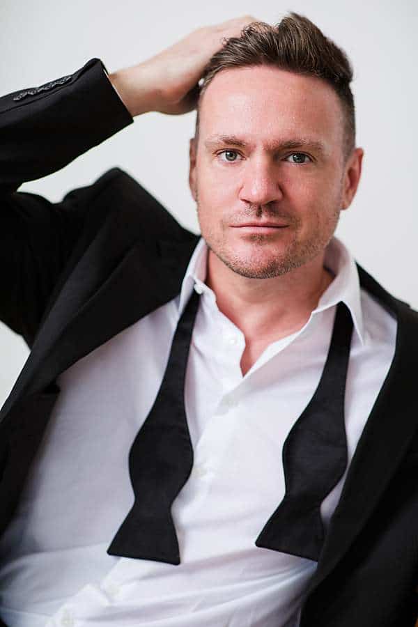 man-portrait-photography-caucasian-man-wearing-tuxedo-tie-opened-hand-brushing-back-hair