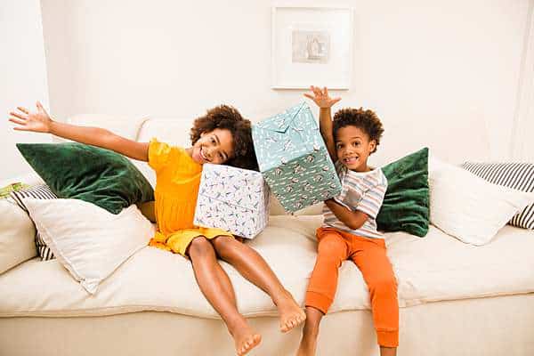 Children-model-holding-presents-in-curlicue-eco-wrapping-paper-with-smiles-by-london-website-photographer