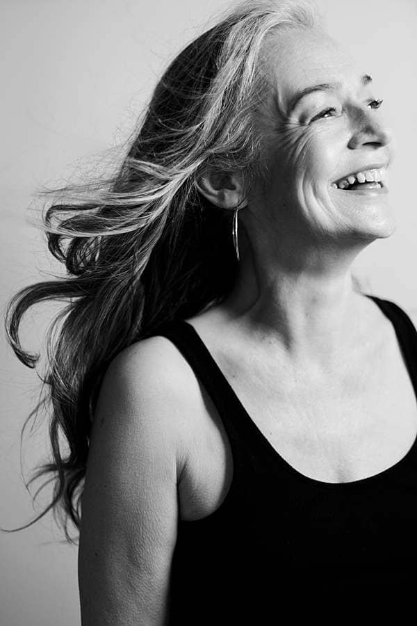 Black and white candid portrait of a smiling mature woman with natural expression