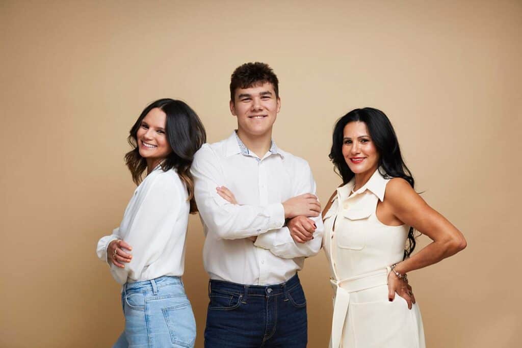 Mother with adult daughter and son posing in neutral studio portrait, elegant family photography London